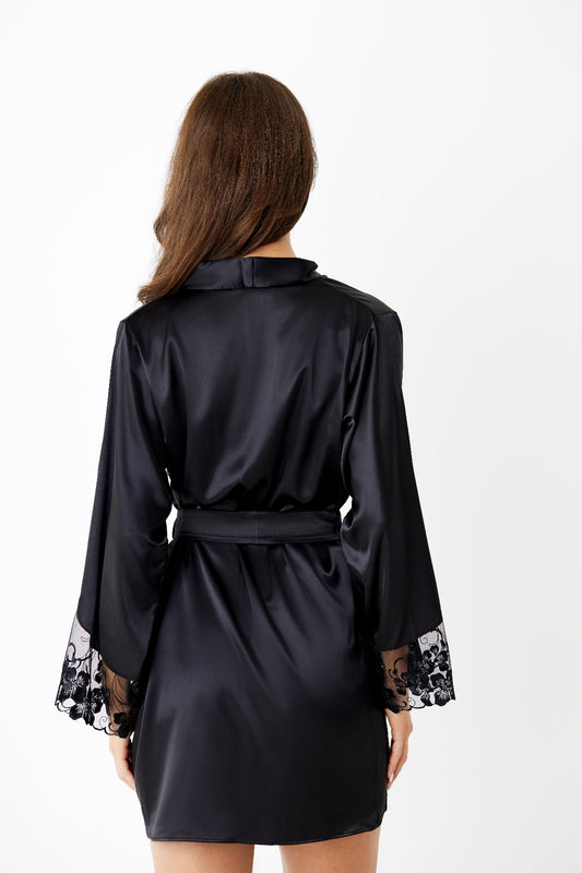 Valerie Black satin robe with European embroidery lace cuffs and hem and 24 kt gold-plated hardware, back view on model against light-grey backdrop. 