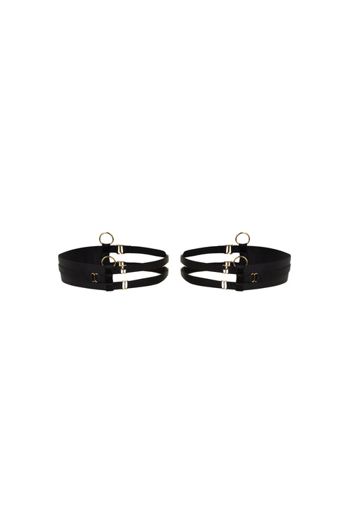 Kate black thigh garters with wide bands, slim adjustable straps and gold-tone hardware on a white background.