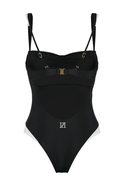 Back view of the Monaco black and ivory one-piece swimsuit with open back, logo embroidery, ivory framing and gold-tone hardware on a white background.