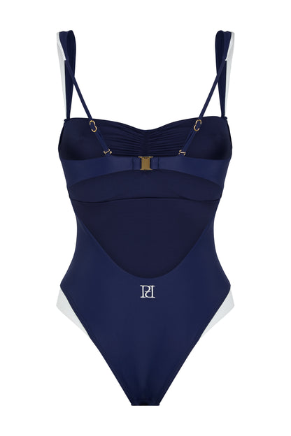 Back view of the Monaco navy and ivory one-piece swimsuit with open back, logo embroidery, ivory contouring and gold-tone hardware on a white background.